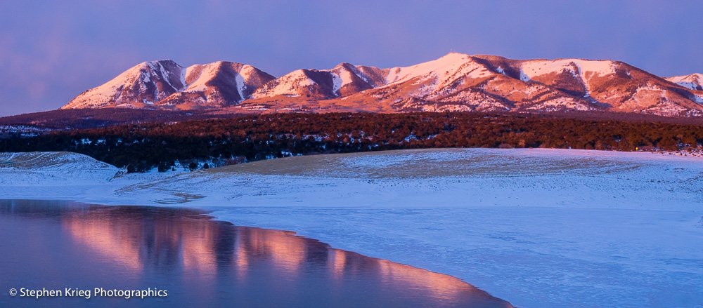 The just-risen sun lights up the Abajo Mountains with a pink glow in January, near Monticello, Utah.